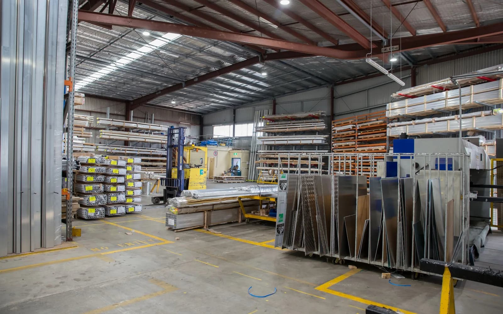 Shrink-wrapped commercial pallets being moved by forklift in a distribution warehouse